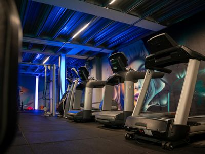 Modern gym interior with soft blue lighting.